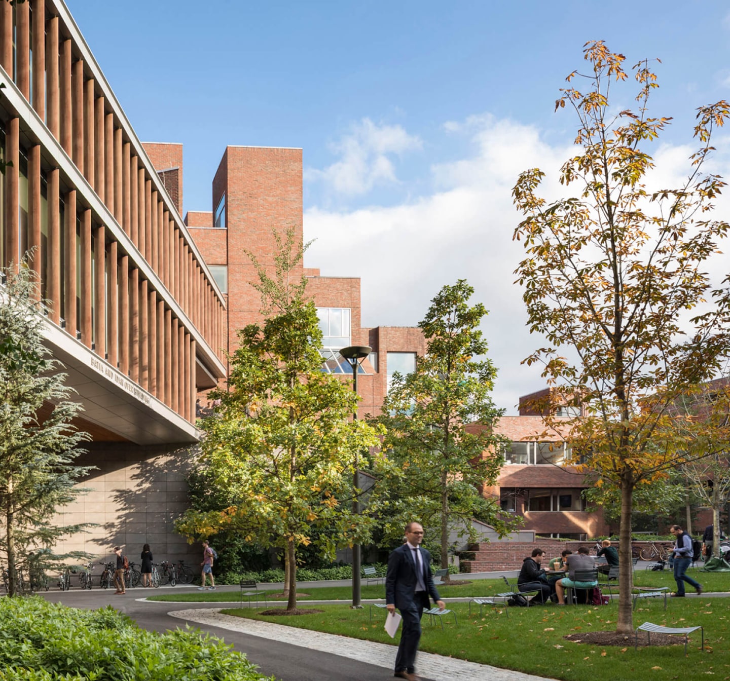 Exterior of a Harvard Kennedy School building beside a tree and walkway.