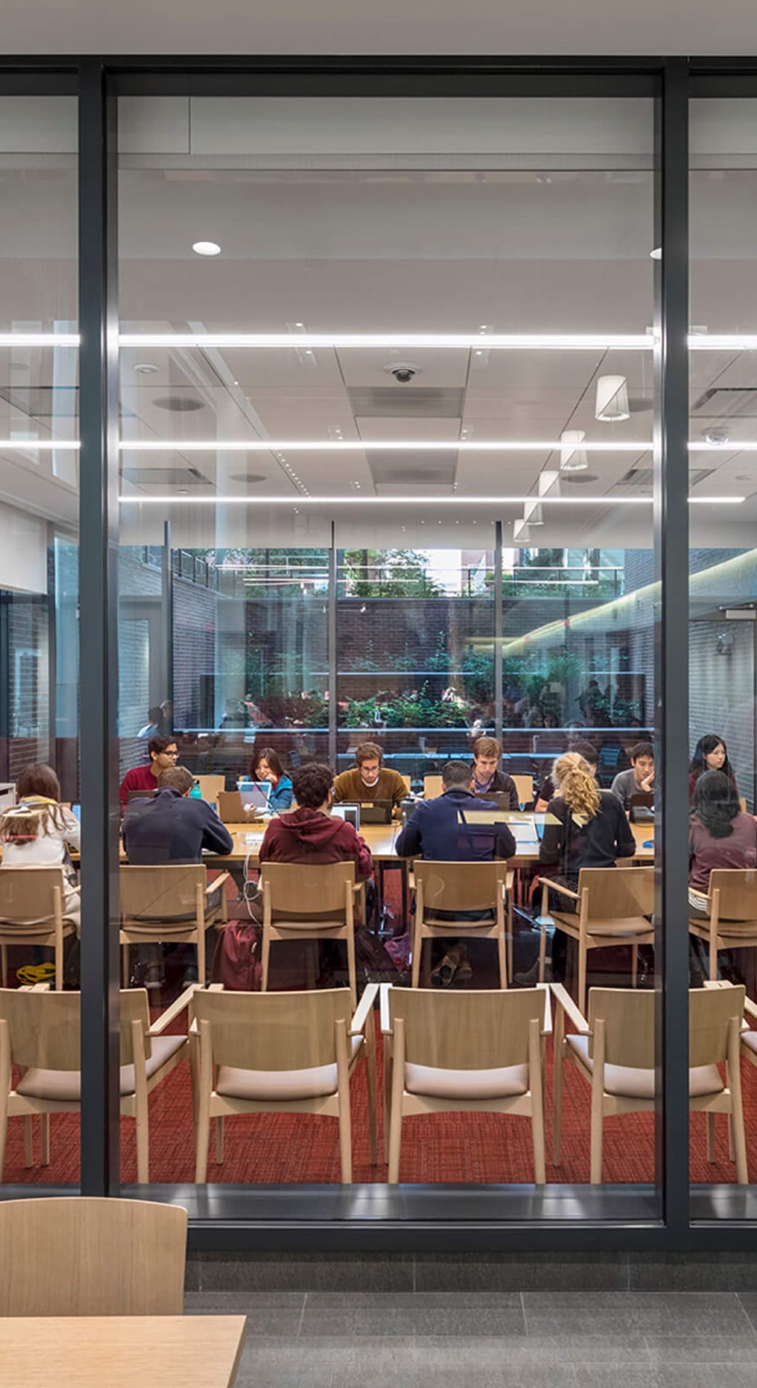 A bright, modern student workroom with tables and chairs during a Propeller review session.