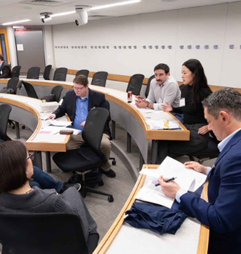 Participants collaborate at tiered tables during a working session.