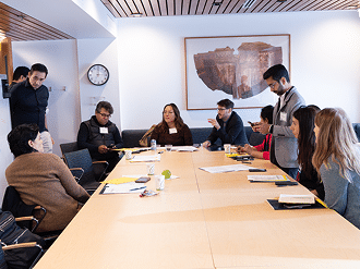 Participants seated around a large table during a negotiation simulation.