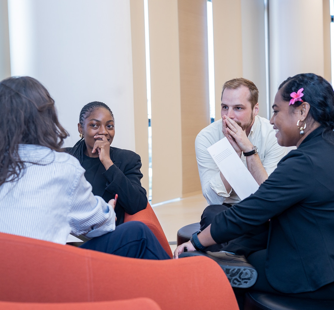 Anselm Dannecker and other participants work through a negotiation exercise at a table.