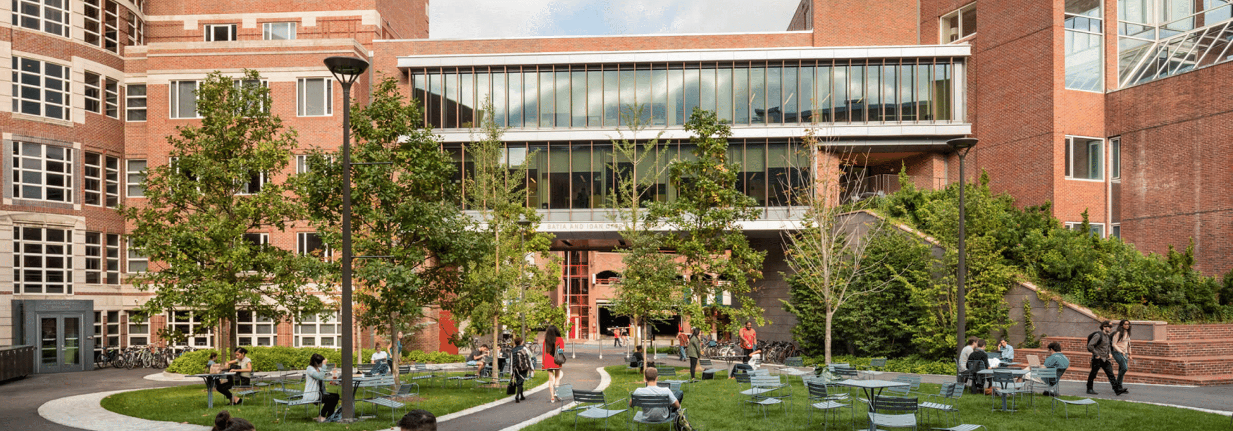 Exterior of the Harvard Kennedy School campus with walkways and landscaped greenery.