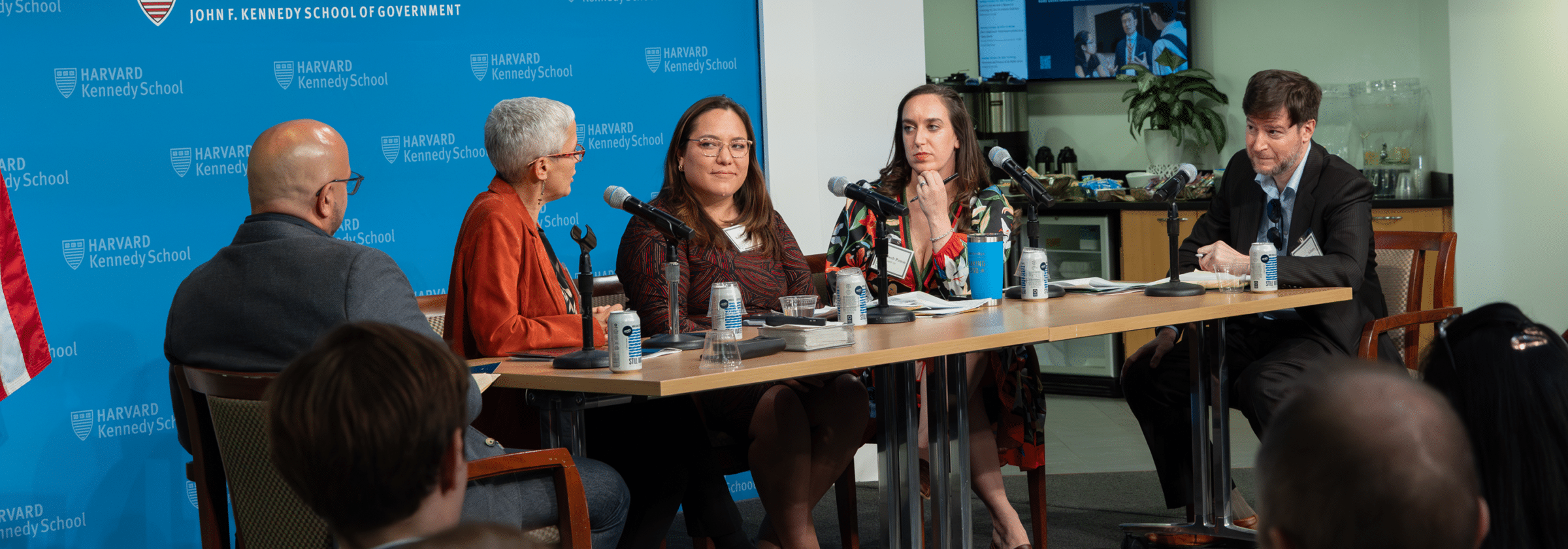 Panelists speak at a microphone-equipped table during an NCRC event at the Harvard Kennedy School Forum.
